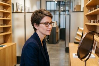 Femme essayant des lunettes dans une opticienne moderne à Saint-Étienne