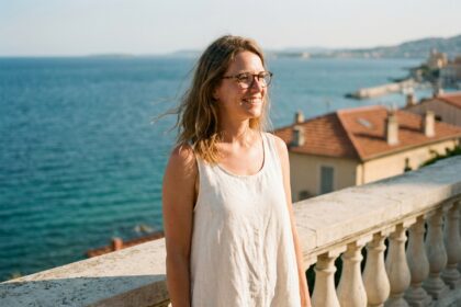 Femme élégante portant des lunettes en écaille de tortue sur la promenade de la Côte d'Azur avec vue sur la mer Méditerranée